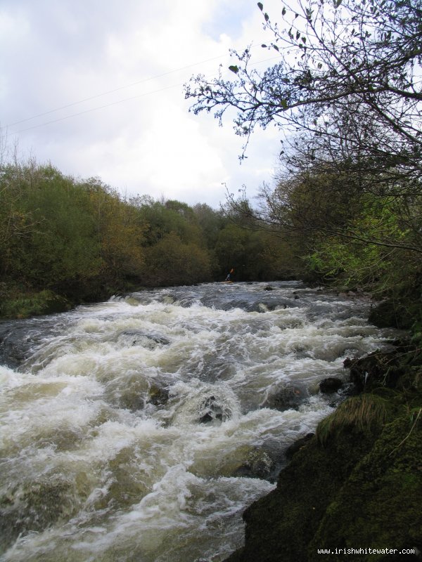 The big rapid on the river running into a small gorge section a house is perched high on the left bank at the bottom of the rapid before the bends through the little gorge