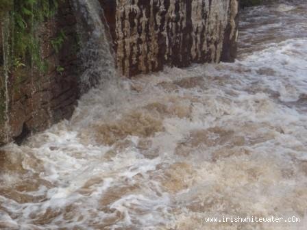 Under the bridge.The small undercut that we use as a gauge is barely visible river left.If there's a cushion wave forming off the bridge pillar your in for a good time 